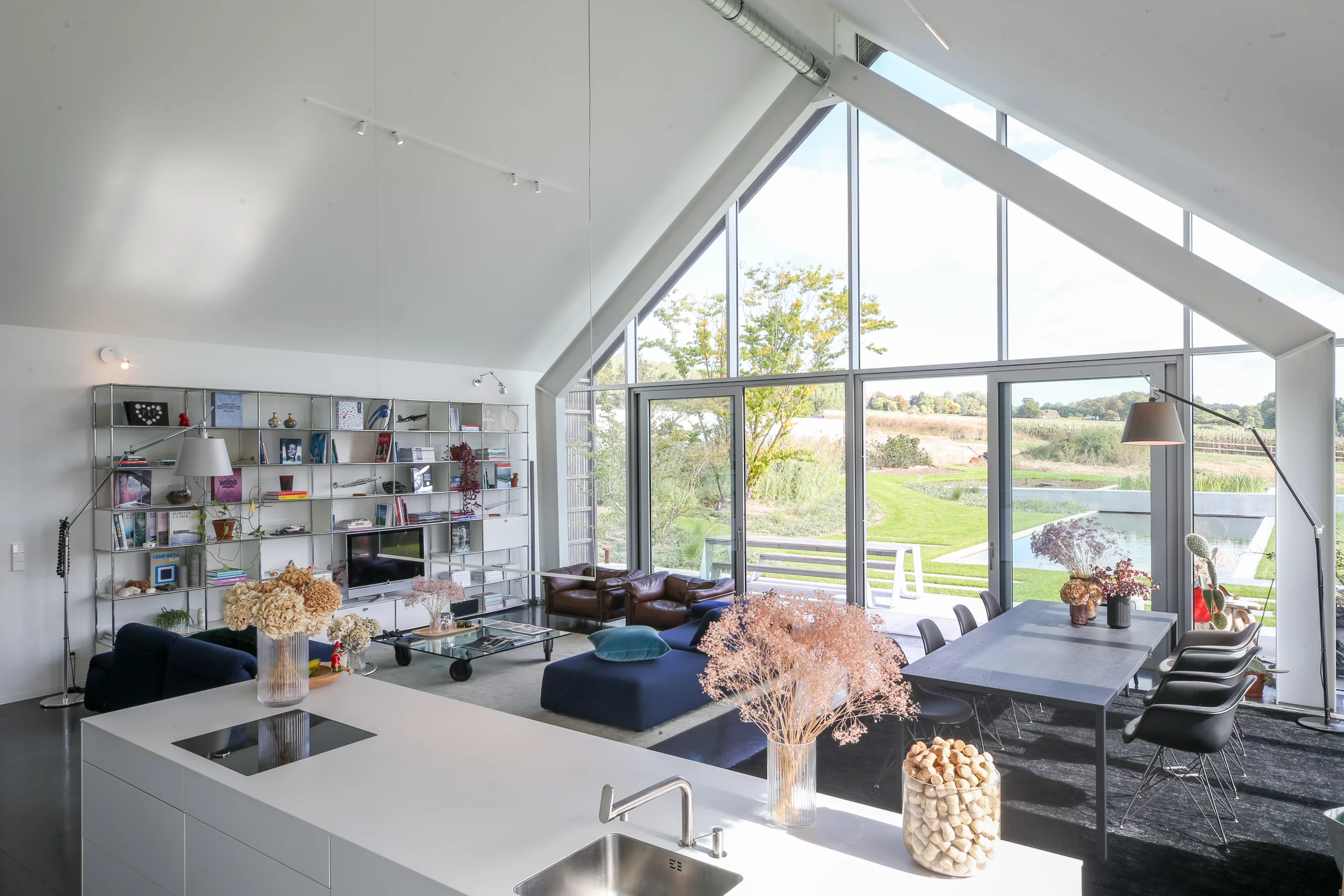 Vivez l'expérience d'un intérieur moderne et lumineux conçu par Atelier MW, avec de grandes fenêtres et une décoration élégante.